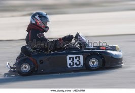 go-kart-racer-in-kart-number-33-whizzing-by-on-an-asphalt-track-ae5mmh.jpg